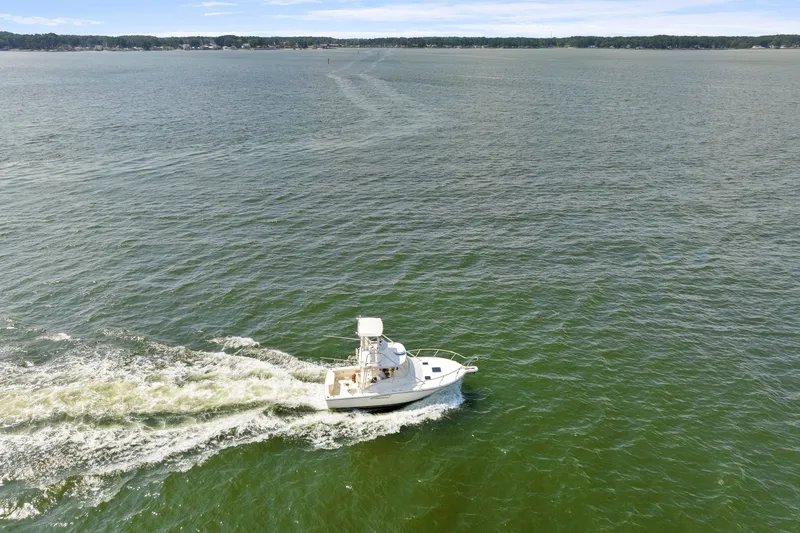 Slide: The Image of Aerial view of 1995 Pursuit 3000 Offshore boat cruising on open water. - 61