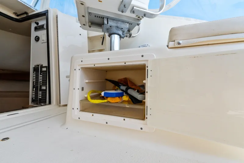 Slide: The Image of Storage compartment on a 1995 Pursuit 3000 Offshore boat, containing tools and equipment. - 32