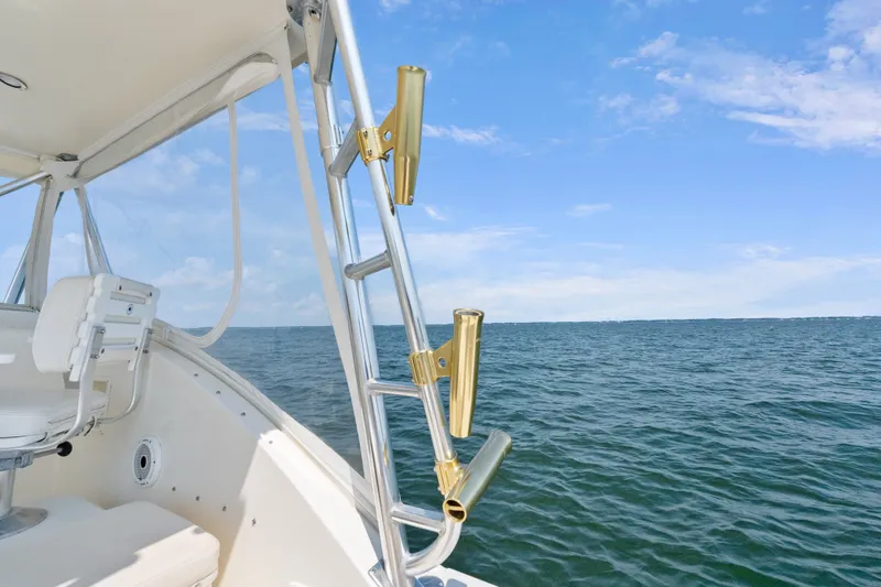 Slide: The Image of 1995 Pursuit 3000 Offshore boat with rod holders, ocean view, and clear blue sky. - 30