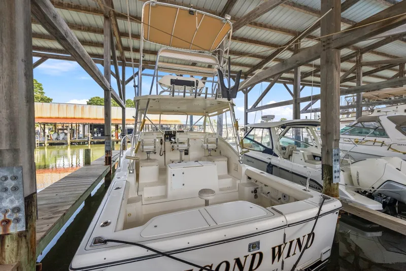 Slide: The Image of 1995 Pursuit 3000 Offshore boat docked in a covered marina. - 33