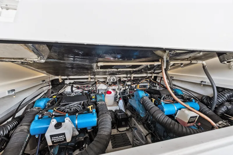 Slide: The Image of Engine compartment of a 1995 Pursuit 3000 Offshore boat, showcasing dual engines and wiring. - 67