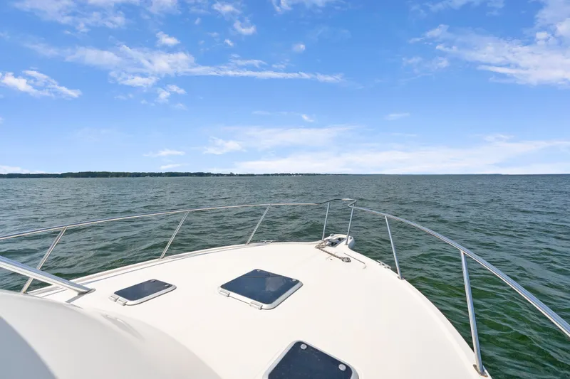 Slide: The Image of Bow view of a 1995 Pursuit 3000 Offshore boat on open water under a clear sky. - 39