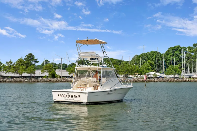 Slide: The Image of 1995 Pursuit 3000 Offshore boat named "Second Wind" on calm water near marina. - 54