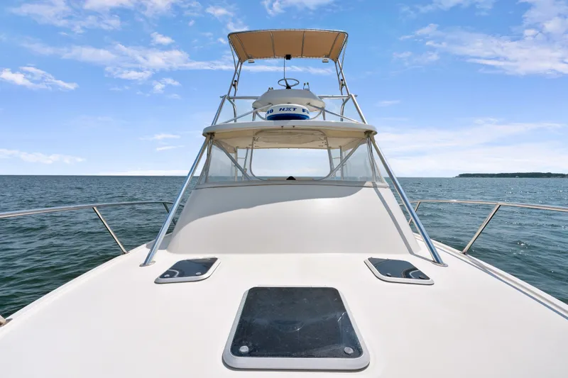 Slide: The Image of 1995 Pursuit 3000 Offshore boat on open water under clear blue sky. - 41