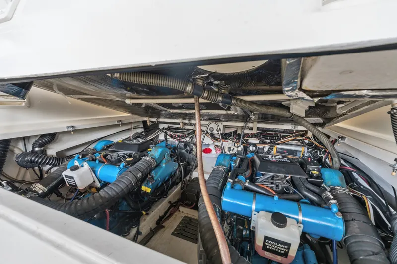 Slide: The Image of Engine compartment of a 1995 Pursuit 3000 Offshore boat, showcasing dual engines and wiring. - 69