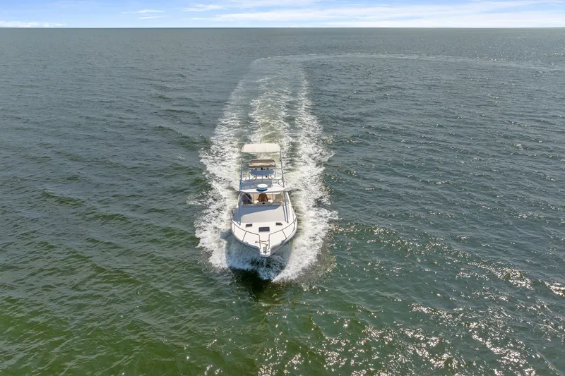 Slide: The Image of Aerial view of 1995 Pursuit 3000 Offshore boat cruising on open water. - 63