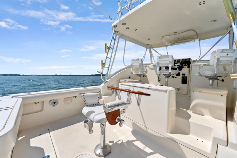 Slide: The Image of 1995 Pursuit 3000 Offshore boat interior with fishing chair and helm, on open water. - 22