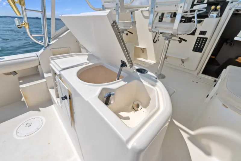 Slide: The Image of 1995 Pursuit 3000 Offshore boat interior with open sink and seating area. - 24