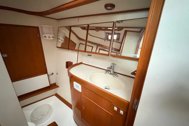 Slide: The Image of Bathroom interior of a 1998 Hylas 46 yacht with wooden cabinetry and mirrors. - 14