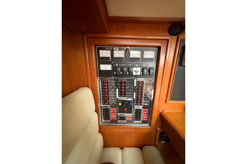 Slide: The Image of Control panel inside a 1998 Hylas 46 yacht, featuring various switches and gauges. - 17