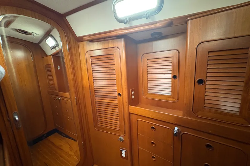 Slide: The Image of Interior of a 1998 Hylas 46 yacht featuring wooden cabinetry and doors. - 16