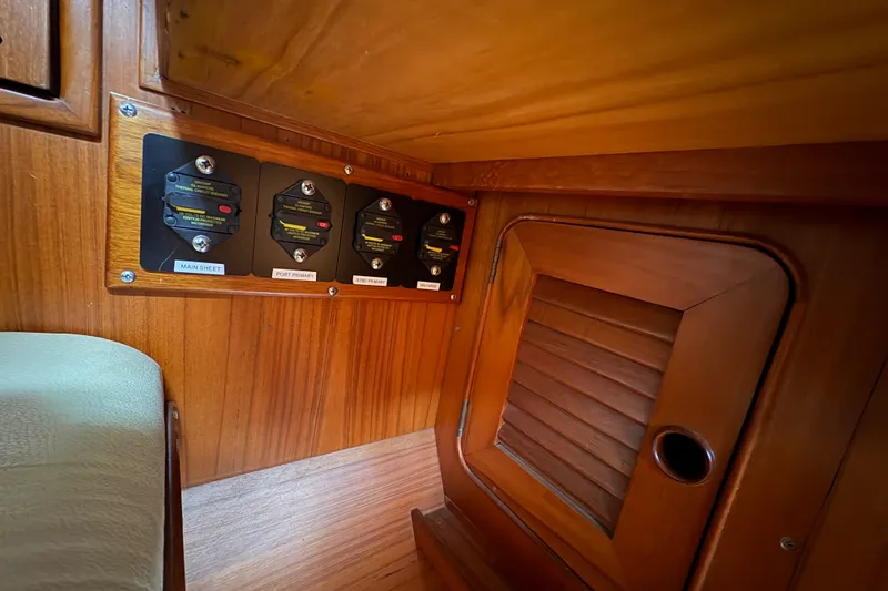 Slide: The Image of Wooden interior of a 1998 Hylas 46 yacht featuring control panels and a vented cabinet door. - 22