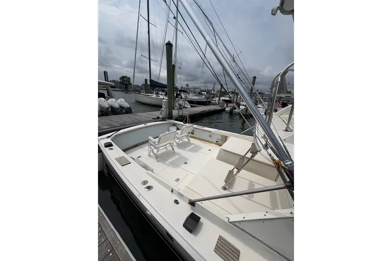 Slide: The Image of 1974 Bertram 31 Flybridge Cruiser docked at marina, showcasing spacious deck and seating. - 14