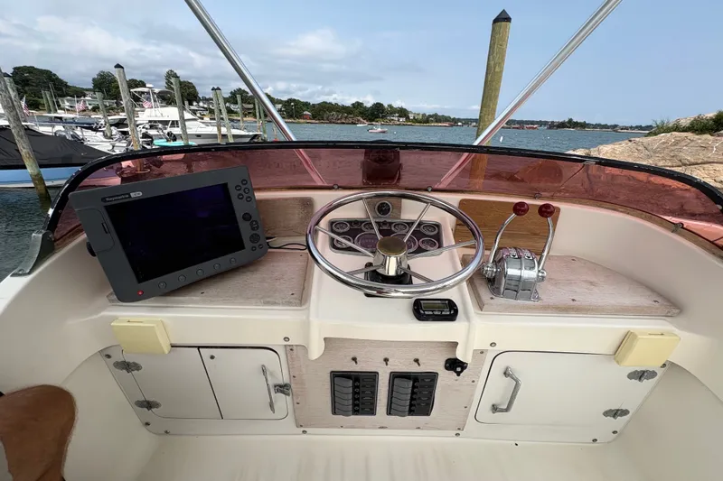 Slide: The Image of 1974 Bertram 31 Flybridge Cruiser helm with steering wheel and navigation equipment. - 21