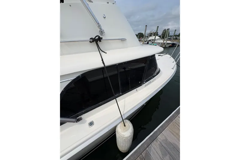 Slide: The Image of 1974 Bertram 31 Flybridge Cruiser docked, featuring sleek design and classic white exterior. - 9