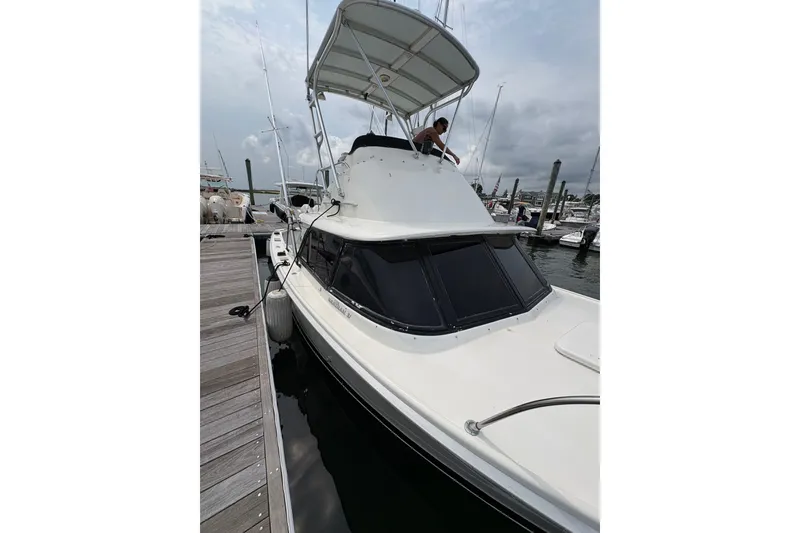 Slide: The Image of 1974 Bertram 31 Flybridge Cruiser docked at marina, overcast sky. - 10