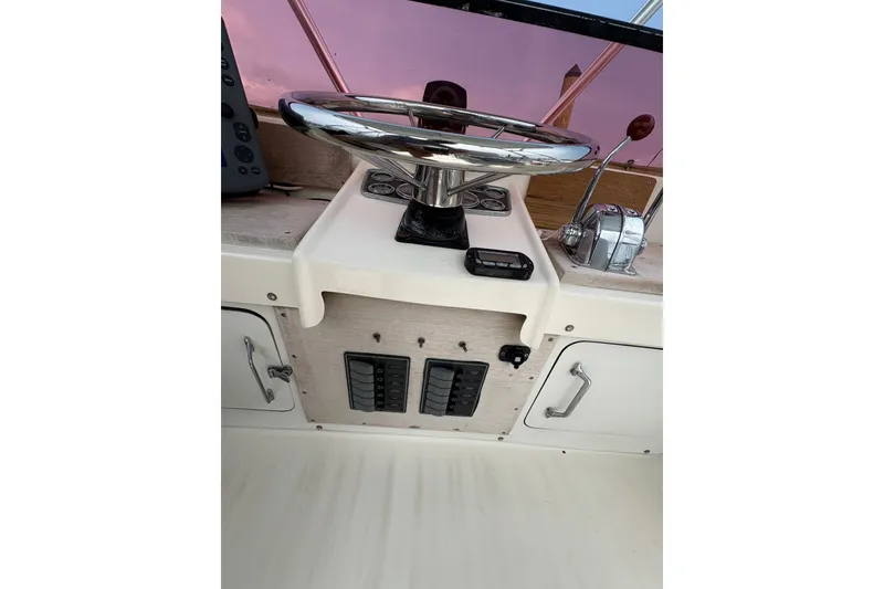 Slide: The Image of 1974 Bertram 31 Flybridge Cruiser helm with steering wheel and control panel. - 22