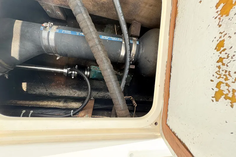 Slide: The Image of 1974 Bertram 31 Flybridge Cruiser engine compartment with hoses and fittings. - 32