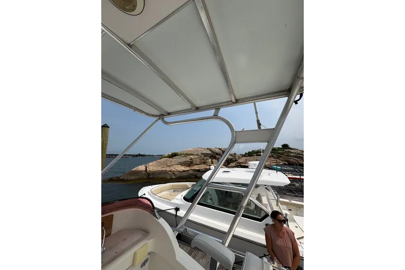 Slide: The Image of 1974 Bertram 31 Flybridge Cruiser docked near rocky shoreline, partial view of interior and exterior. - 25