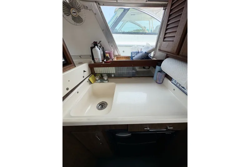Slide: The Image of 1974 Bertram 31 Flybridge Cruiser interior with sink and storage area. - 31