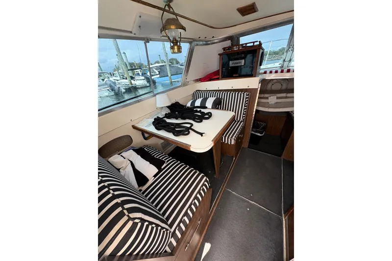 Slide: The Image of Interior of a 1974 Bertram 31 Flybridge Cruiser with striped seating and nautical decor. - 27