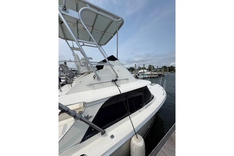 Slide: The Image of 1974 Bertram 31 Flybridge Cruiser docked at marina, side view. - 8