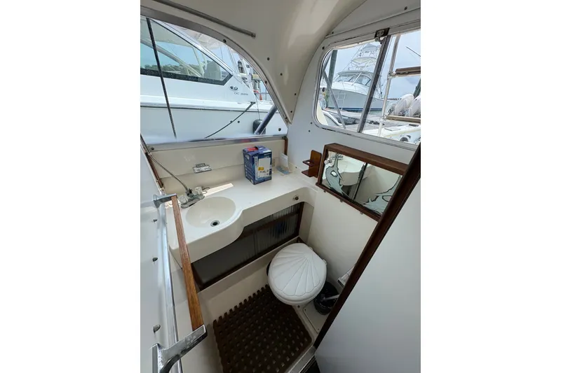 Slide: The Image of 1974 Bertram 31 Flybridge Cruiser bathroom with sink, toilet, and mirror. - 29