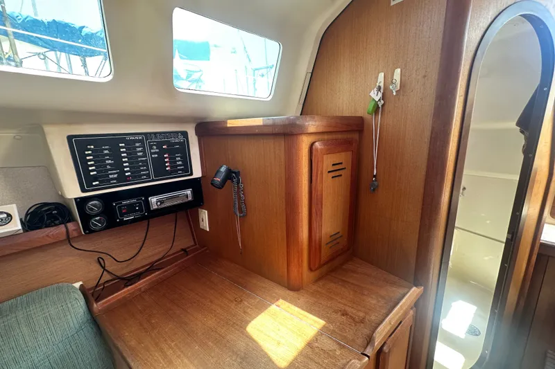 Slide: The Image of Interior of a 1997 Hunter 34 sailboat featuring a control panel and wooden cabinetry. - 21