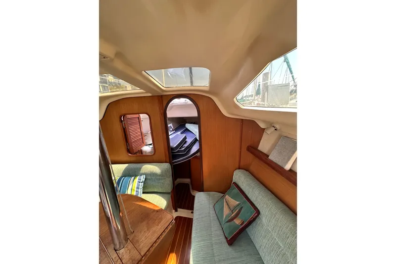 Slide: The Image of Interior of a 1997 Hunter 34 sailboat with cozy seating and wooden accents. - 27