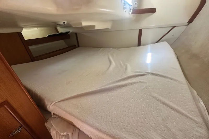 Slide: The Image of Cozy cabin interior of a 1997 Hunter 34 sailboat with a neatly made bed. - 18