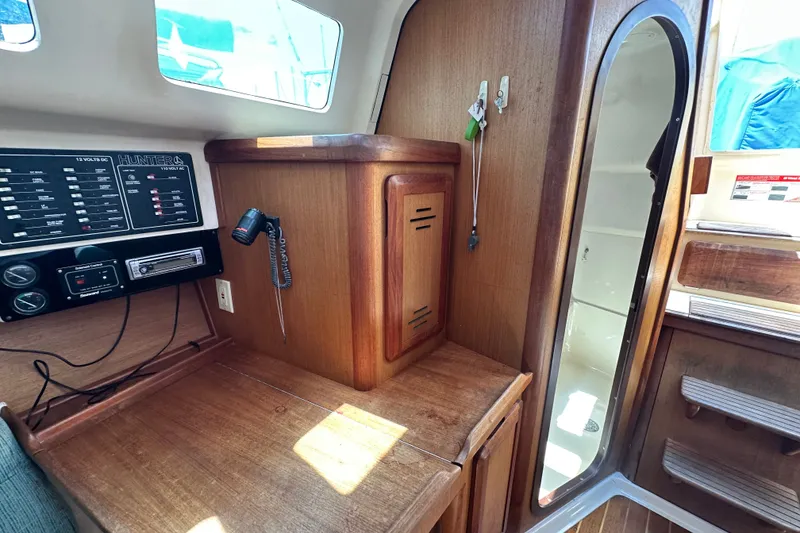 Slide: The Image of Interior of a 1997 Hunter 34 sailboat with control panel and wooden cabinetry. - 22