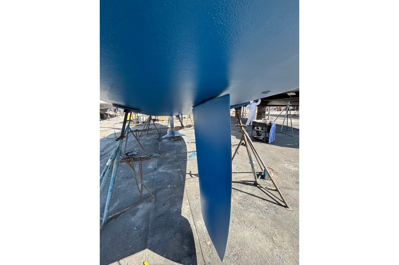 Slide: The Image of Bottom view of a 1997 Hunter 34 sailboat on stands, showing blue-painted keel. - 32