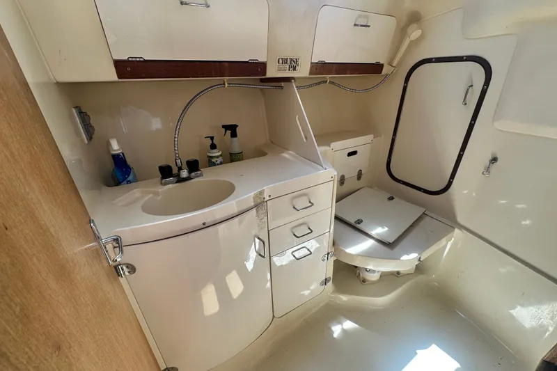 Slide: The Image of 1997 Hunter 34 yacht bathroom with sink, storage cabinets, and marine toilet. - 17