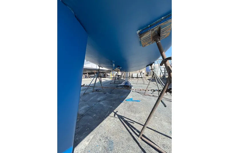Slide: The Image of 1997 Hunter 34 sailboat on stands, blue hull, under maintenance. - 33