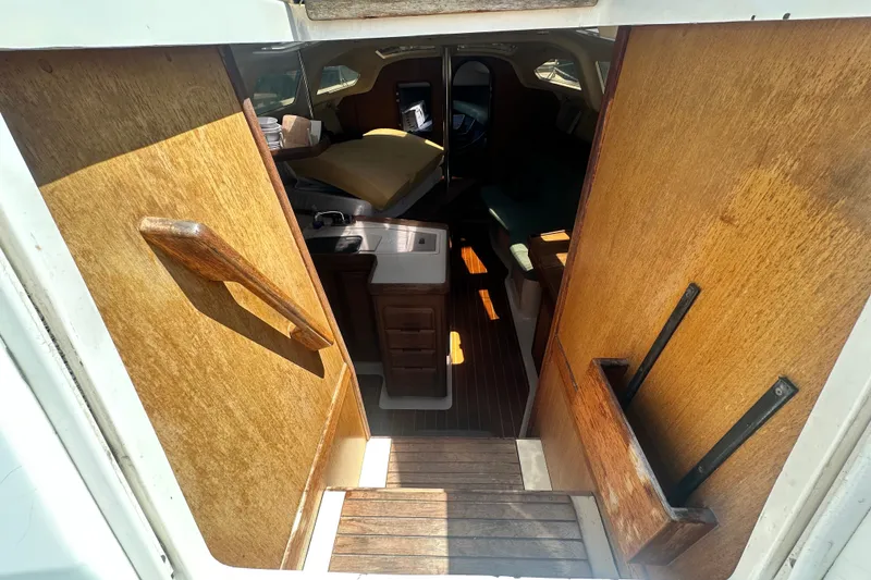 Slide: The Image of Interior view of a 1997 Hunter 34 sailboat cabin with wooden finishes. - 14