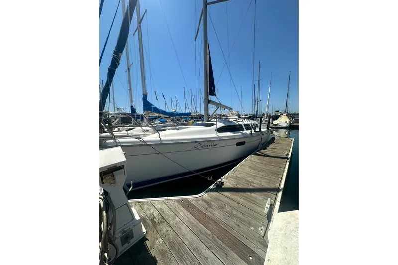 The Image of 1997 Hunter 34 sailboat docked at marina under clear blue sky. - 1