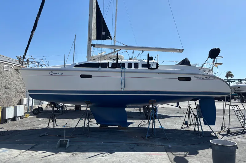 Slide: The Image of 1997 Hunter 34 sailboat on stands in a boatyard under clear blue sky. - 34