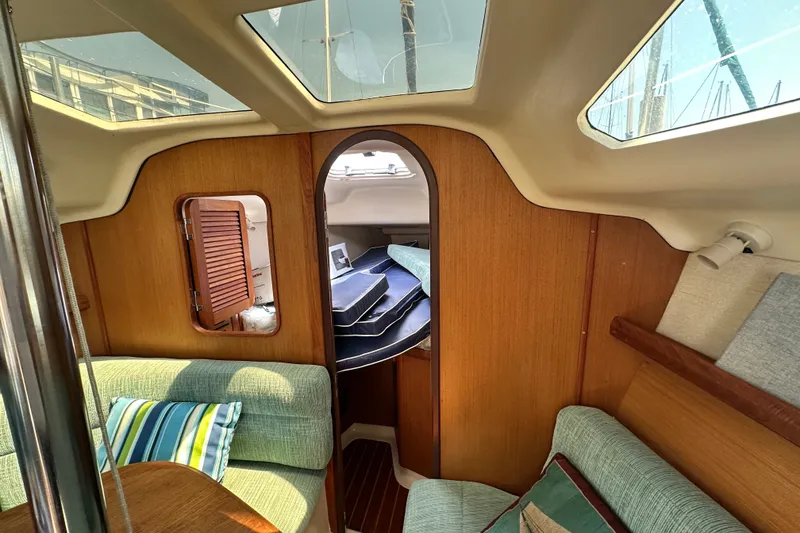 Slide: The Image of Interior of a 1997 Hunter 34 sailboat with cozy seating and wooden paneling. - 26