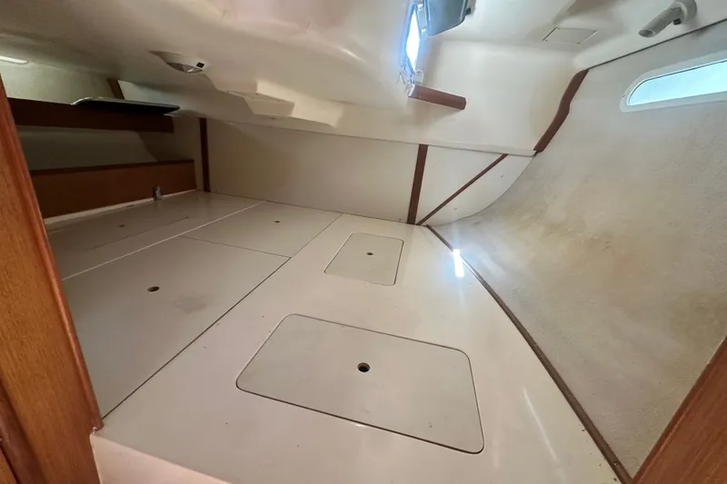 Slide: The Image of Interior cabin of a 1997 Hunter 34 sailboat, featuring storage compartments and a window. - 16