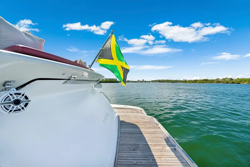 Slide: The Image of 2009 Azimut 86S yacht with Jamaican flag on serene water, clear blue sky. - 47
