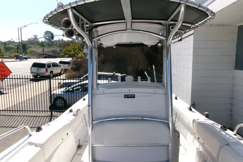 Slide: The Image of 2008 Triumph 235 CC boat with T-top, parked near a road. - 7