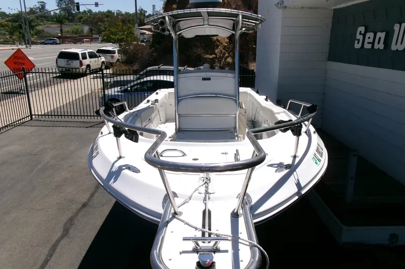 Slide: The Image of 2008 Triumph 235 CC boat with T-top, parked outdoors near a road. - 31