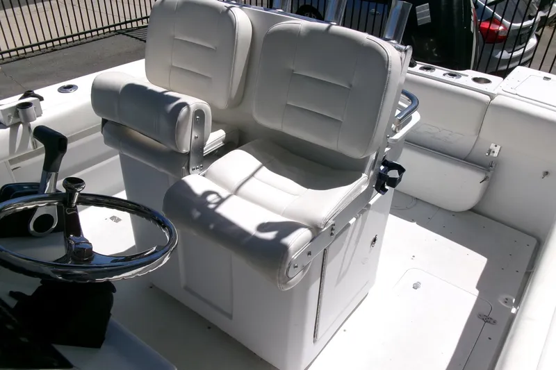 Slide: The Image of 2008 Triumph 235 CC boat interior with white cushioned seating and steering wheel. - 16