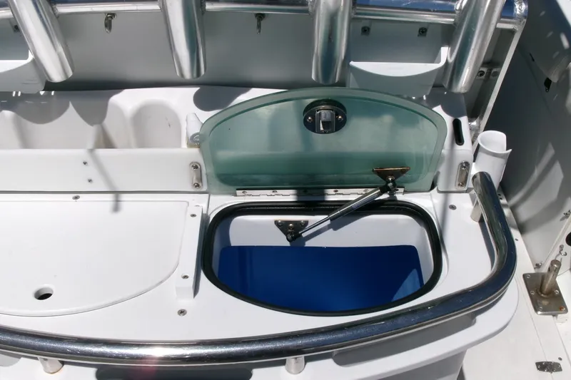 Slide: The Image of 2008 Triumph 235 CC boat interior with open storage compartment and stainless steel railing. - 18