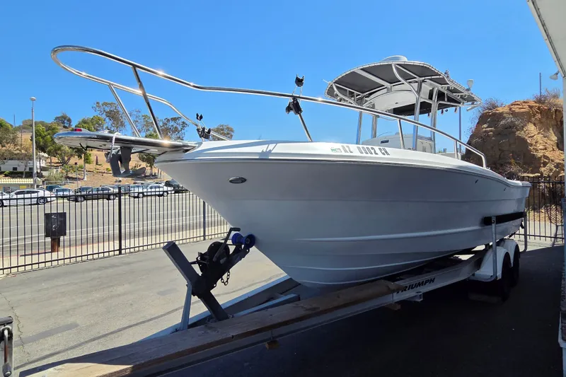 Slide: The Image of 2008 Triumph 235 CC boat on trailer, parked outdoors under clear blue sky. - 1