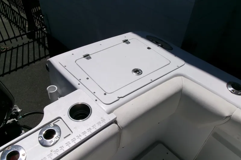 Slide: The Image of 2008 Triumph 235 CC boat interior with storage compartment and cup holders. - 25