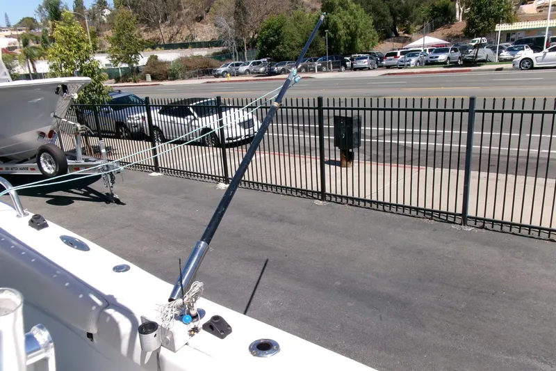 Slide: The Image of 2008 Triumph 235 CC boat on trailer, parked near a fence on a sunny day. - 29