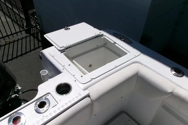 Slide: The Image of 2008 Triumph 235 CC boat interior with open storage compartment and cup holders. - 26