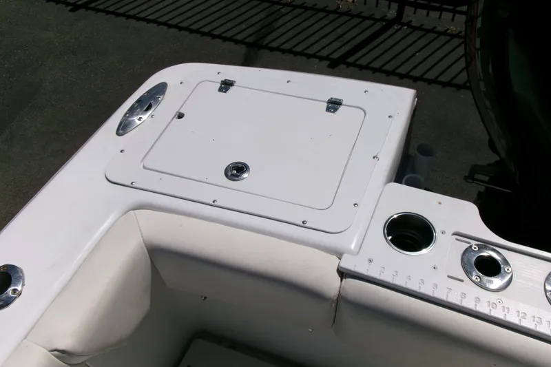 Slide: The Image of 2008 Triumph 235 CC boat interior with storage compartment and cup holders. - 23