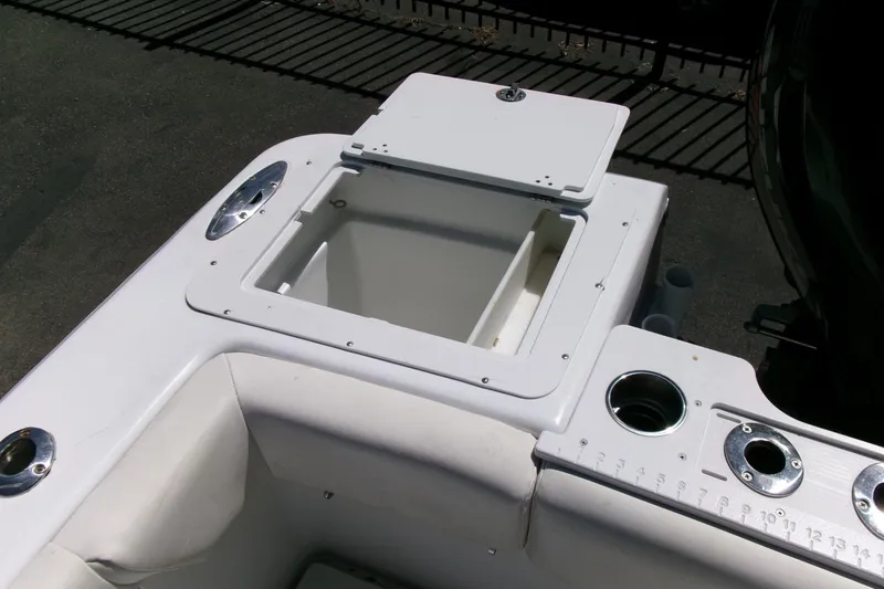 Slide: The Image of 2008 Triumph 235 CC boat interior with open storage compartment and cup holders. - 24